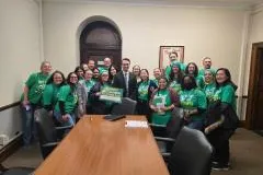 Local 3005 Member during their lobby day holding green signs and wearing green shirts