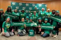 Local 3005 Member during their lobby day holding green signs and wearing green shirts